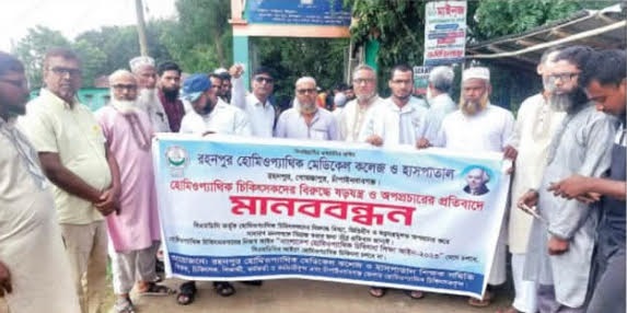 গোমস্তাপুরে হোমিওপ্যাথিক চিকিৎসকের বিরুদ্ধে ষড়যন্ত্র ও অপপ্রচারের প্রতিবাদে মানববন্ধন